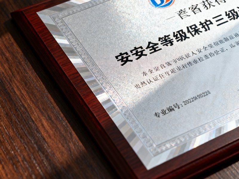 DG视讯获得的信息安全等级保护三级认证证书特写，证书编号清晰可见，背景为深色木质桌面。